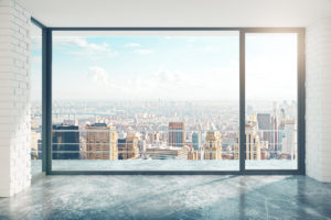 Empty loft style room with concrete floor and city view © peshkov/GettyImages
